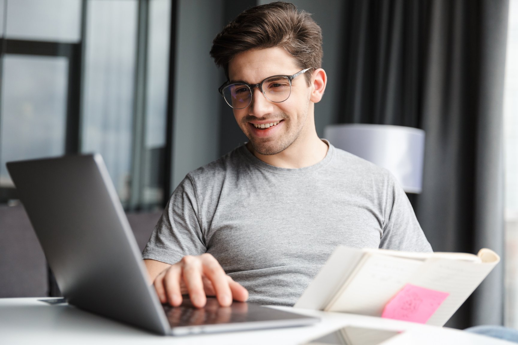 Optimistic Young Man Using Laptop Computer